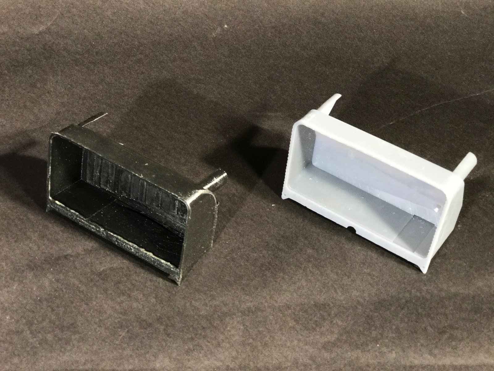  Water tank prototypes. The Grey resin print is the finalized design, with recesses for a water level sensor and strain gauge. 